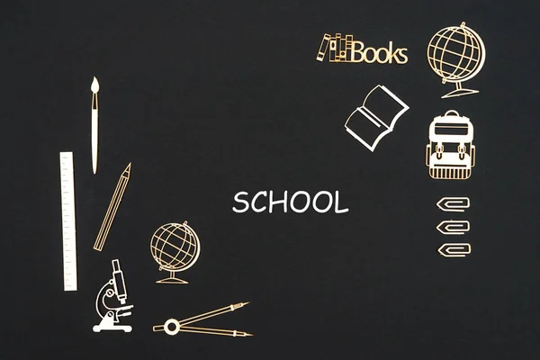 Material escolar colocado sobre fondo negro con escuela de texto — Foto de Stock