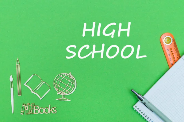 テキスト高校学校用品木製ミニチュア、緑色の背景上のノートブック — ストック写真