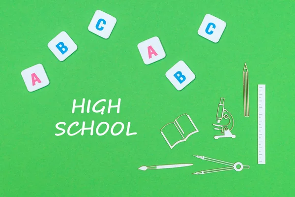 Szöveg high school felülről fa minitures tanszerek és abc betűk zöld háttér — Stock Fotó