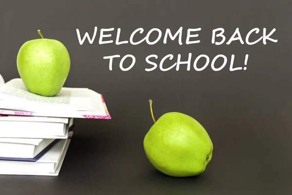 Texto bienvenido de nuevo a la escuela, dos manzanas verdes, libros abiertos con concepto — Foto de Stock