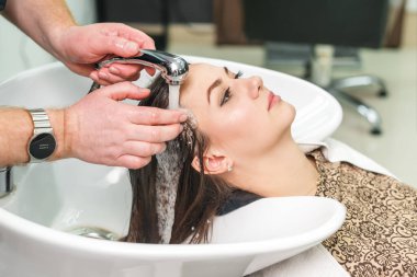 Güzellik salonunda lavaboda ellerini yıkayan kadının saçını kapat..