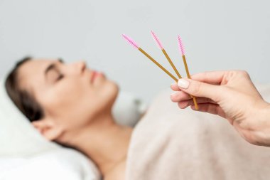 Hastanın arka planında kirpik uzatma fırçaları var, kapat..