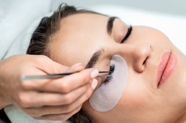 Kirpik uzatma prosedürü uygulayan kadın..