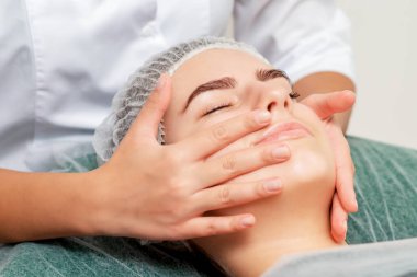 Güzellik salonundaki genç bayanın yüz masajı..