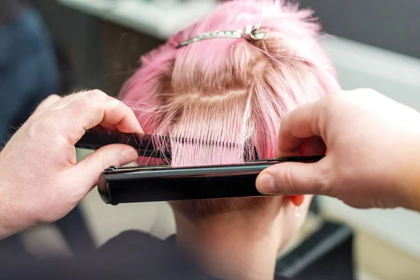 Nahaufnahme Friseur Glättet Kurze Rosa Haare Mit Haarbügeleisen Schönheitssalon Konzept — Stockfoto