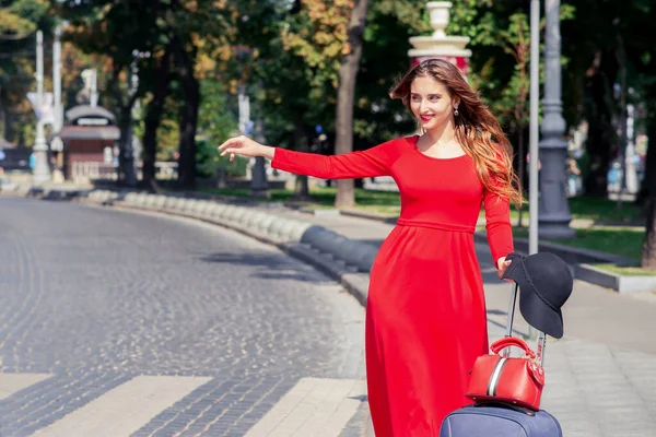 Туристическая Деловая Женщина Красивом Красном Длинном Платье Чемоданом Ловит Такси — стоковое фото