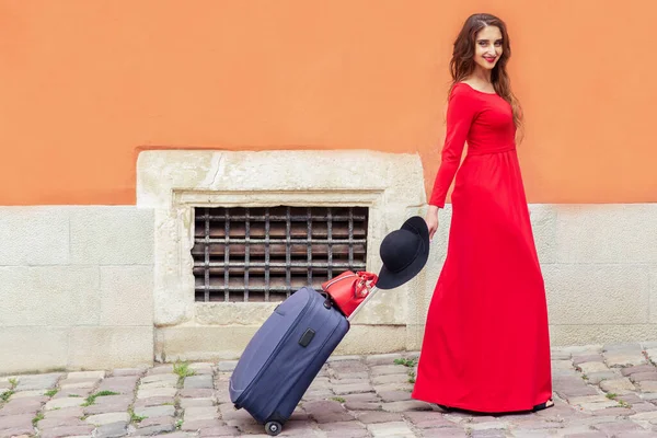 Τουριστική Επιχειρηματίας Όμορφο Κόκκινο Μακρύ Φόρεμα Τραβά Βαλίτσα Στο Δρόμο — Φωτογραφία Αρχείου