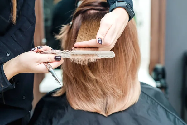 Mãos Femininas Cabeleireiro Estão Segurando Cabelo Vermelho Mulher Com Pente — Fotografia de Stock