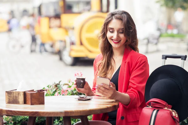 여성을 웃으며 뉴욕의 카페에 전화기를 있습니다 여행하는 카페에서 스마트폰을 있습니다 — 스톡 사진