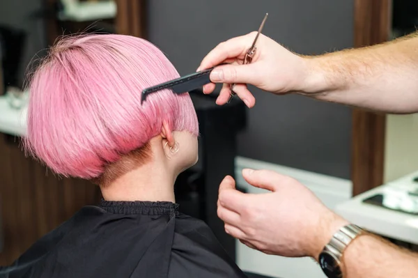 理发师的特写镜头是在美发厅里梳理客户的粉色头发 女客户在理发店里被梳理 女人的发型切割 — 图库照片
