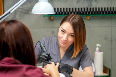 Kadın güzellik salonunda manikür yaptırıyor..