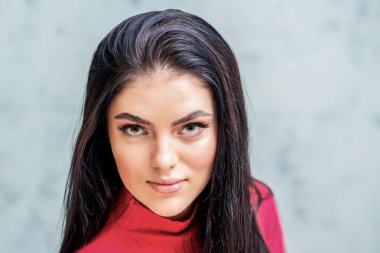 Uzun kirpikleri ve güzel makyajı var. Gri arka planda, fotokopi alanı olan güzel bir kadın..