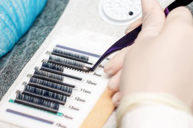 Usta kirpik eklentisi için aksesuar ve araçları alır.