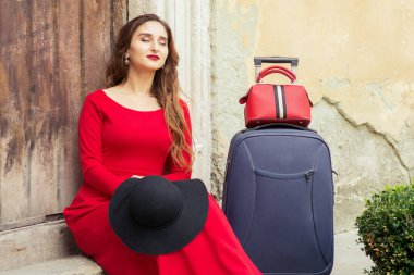 Kadın, şehrin eski ahşap kapısının üzerinde dinlenmek için merdivenlere oturdu..