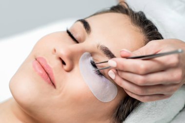 Kirpik uzatma prosedürü uygulayan kadın, kapat.