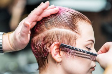 Kuaför kuaförde bir kadının saçını tarıyor..