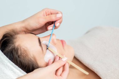 Kirpik uzatma prosedürünü uygulayan güzel bir genç kadın..