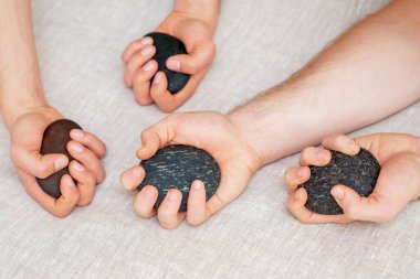 Spa taşları tutan adamların elleri. Masaj konsepti.