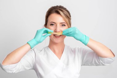 Sıvı şeker yapıştırıcısını bıyık gibi tutan güzellik uzmanı, kapat..