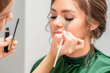 Makyöz kadının kirpiklerine göz farı sürüyor, kapat..