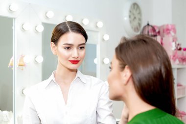Makyaj sanatçısı istemciyle çalışmaya hazır görünüyor.