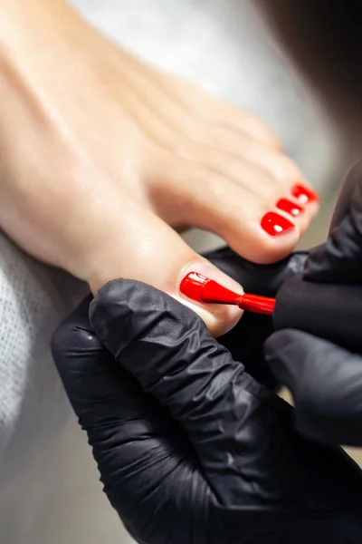 Handen Zwarte Handschoenen Schilderen Teennagels Rode Kleur Pedicure Manicure Teennagels — Stockfoto
