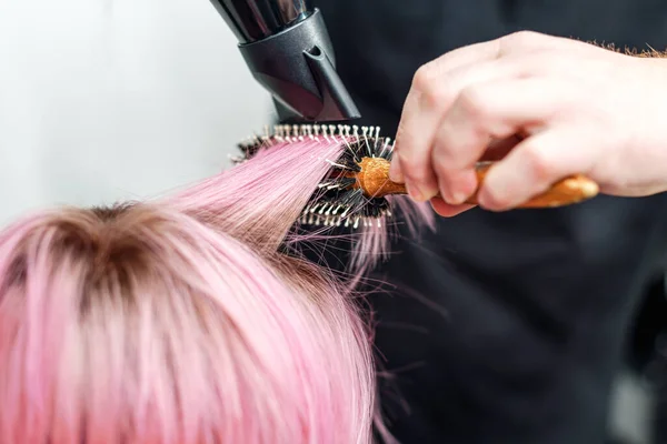 理发师的手正在用吹风机把短而粉色的头发吹干 — 图库照片