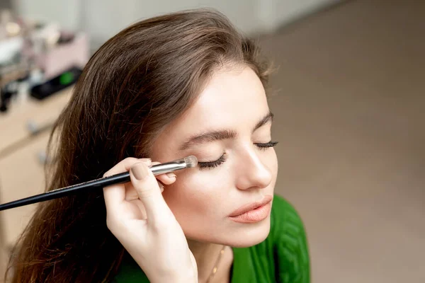 Makeup Artist Applicerar Ögonskugga Pulver Med Borste För Ung Kvinna — Stockfoto