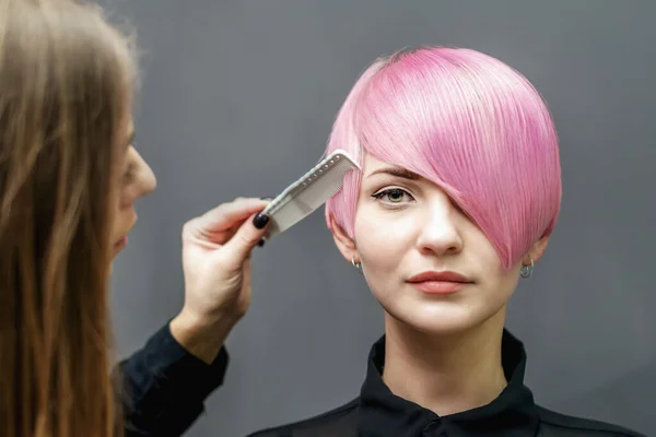 Cabeleireiro Está Penteando Penteado Rosa Curto Mulher Jovem Fundo Cinza — Fotografia de Stock