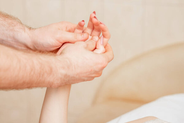 Массаж рук женщины в спа салоне крупным планом
.