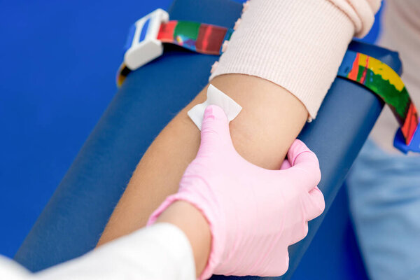 Медсестра дезинфицирует кожу руки хлопка перед введением вакцины в медицинский центр
.