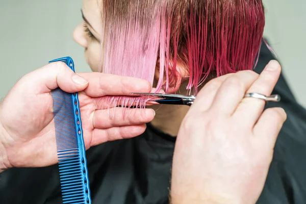 男理发师正在给女人剪短粉色的头发 — 图库照片