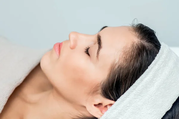 Beautiful woman with closed eyes lying ready for skin care and procedures.