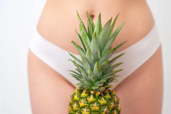 Pineapple on woman\'s body in white panties background, epilation concept, intimate hygiene.