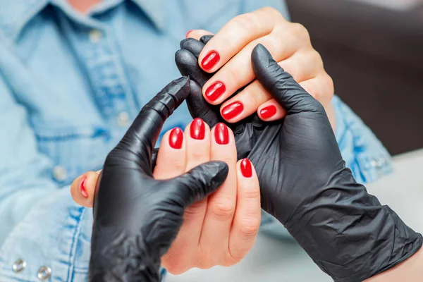 Manicure Houdt Handen Met Rode Nagels Van Vrouw Client Close — Stockfoto