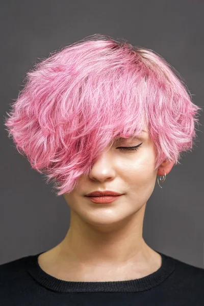 若いです女性の肖像新しい短いピンクの髪型とグレーの背景に目を閉じて — ストック写真