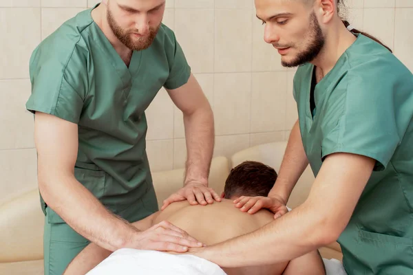 Homem Recebendo Massagem Nas Costas Quatro Mãos Por Dois Massagistas — Fotografia de Stock