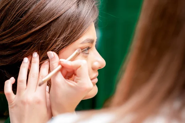 stock image Close up hand of makeup artist applying eyeshadow powder, eye makeup with copy space.