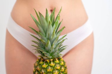 Beyaz kadın külotunun arka planında ananas yaprakları. Epilasyon, tüy dökümü ya da yakın hijyen kavramı.