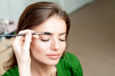 Kaşlarını fırçalayan kadının makyaj malzemesi fotokopi alanı.