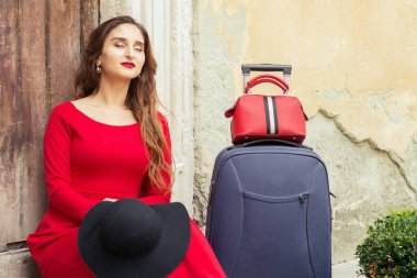 Kadın, şehrin eski ahşap kapısının üzerinde dinlenmek için merdivenlere oturdu..