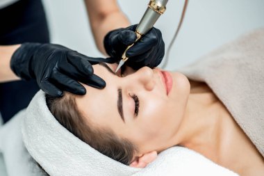 Profesyonel kozmetolojist tarafından kaşlara kalıcı makyaj.