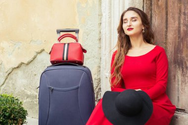 Kadın, şehrin eski ahşap kapısının üzerinde dinlenmek için merdivenlere oturdu..