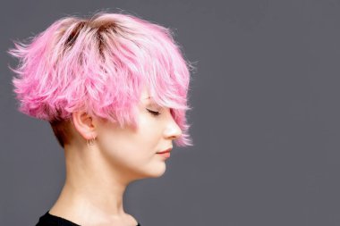 Pembe saç stili olan kadın, kapalı gözlü, gri arka planda, kopyalama alanı olan bir kadın..