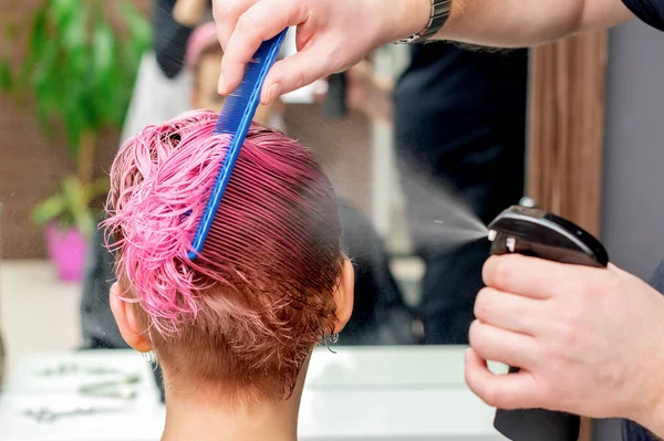 美容師は女性のクローズアップの髪に水を振りかける — ストック写真