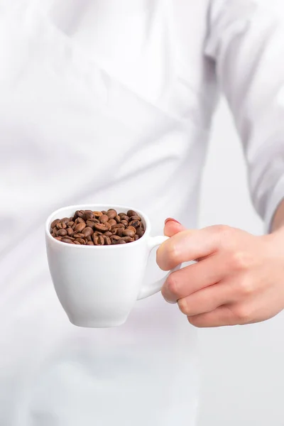 Tasse Kaffeebohnen Weiblicher Hand Des Arztes Auf Weißem Hintergrund Nahaufnahme — Stockfoto