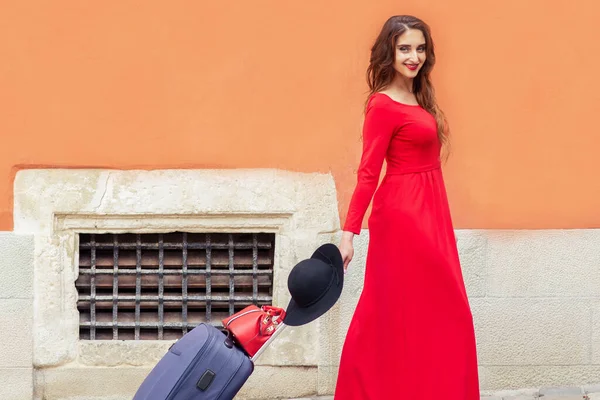 Podróżująca Kobieta Czerwonej Długiej Sukience Ciągnąca Walizkę Ulicy Miasta — Zdjęcie stockowe