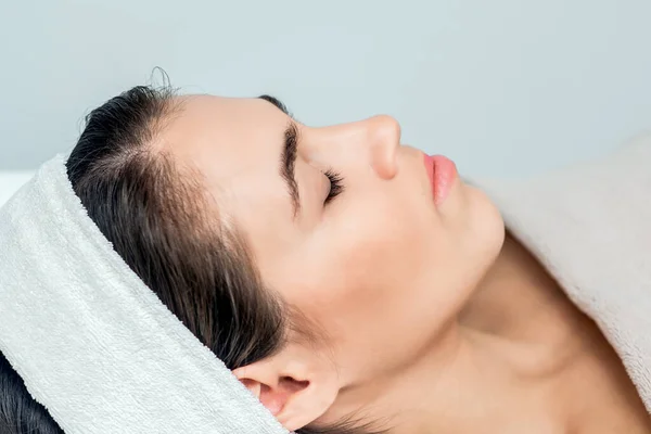 Face of woman with closed eyes before procedure ready for face skin care.