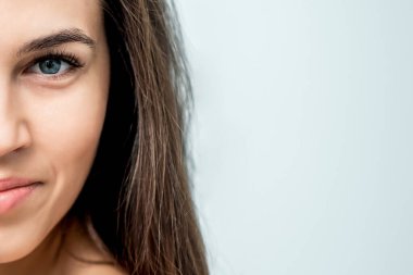 Beyaz arkaplanda izole edilmiş, fotokopi alanı olan bir kadının yarı yüzü.