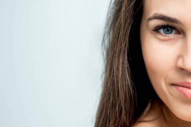 Beyaz arkaplanda izole edilmiş, fotokopi alanı olan bir kadının yarı yüzü.